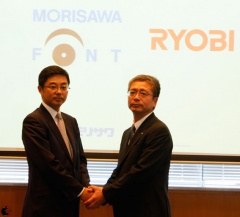 固く手を握り、末長い事業の継続を約束した 株式会社モリサワ 森澤彰彦 代表取締役社長 と リョービイマジクス株式会社 筆谷清隆 代表取締役社長